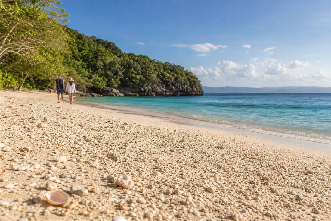 Visitors walking along Puka Shell Beach in Boracay