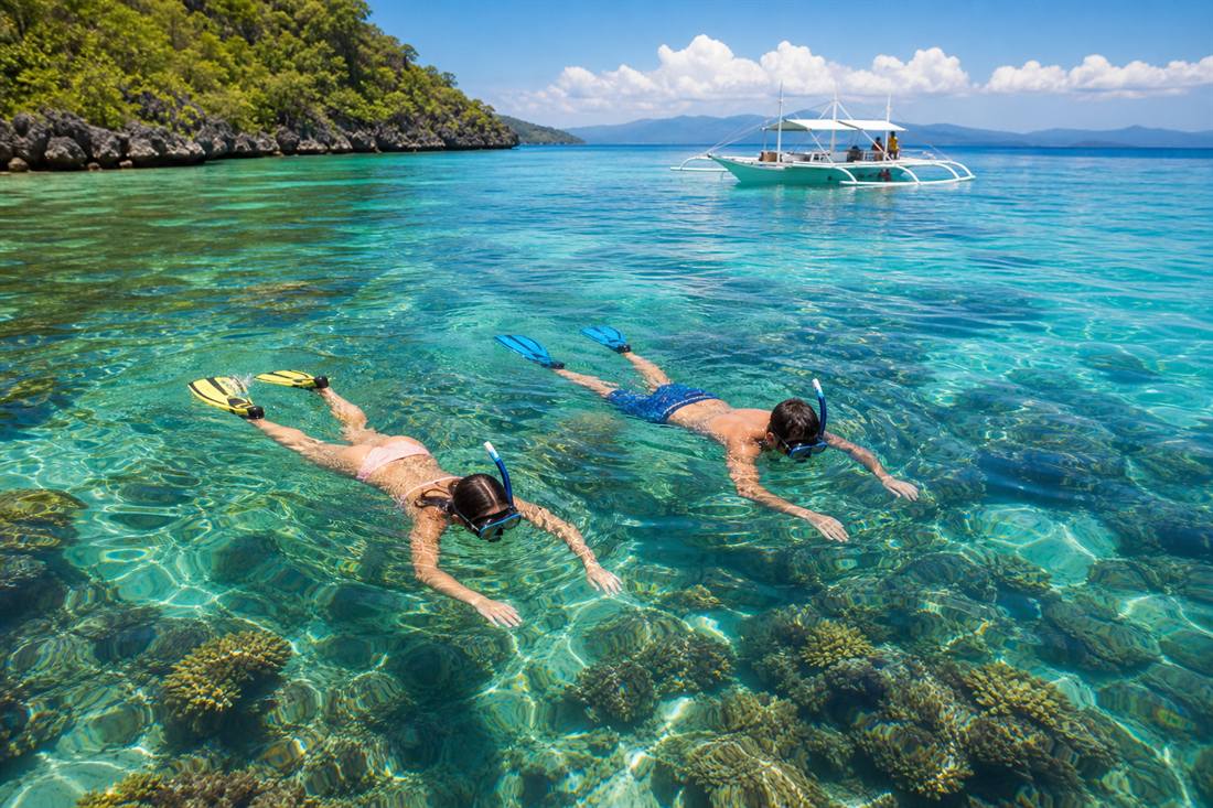 Travelers snorkeling in clear water near Boracay
