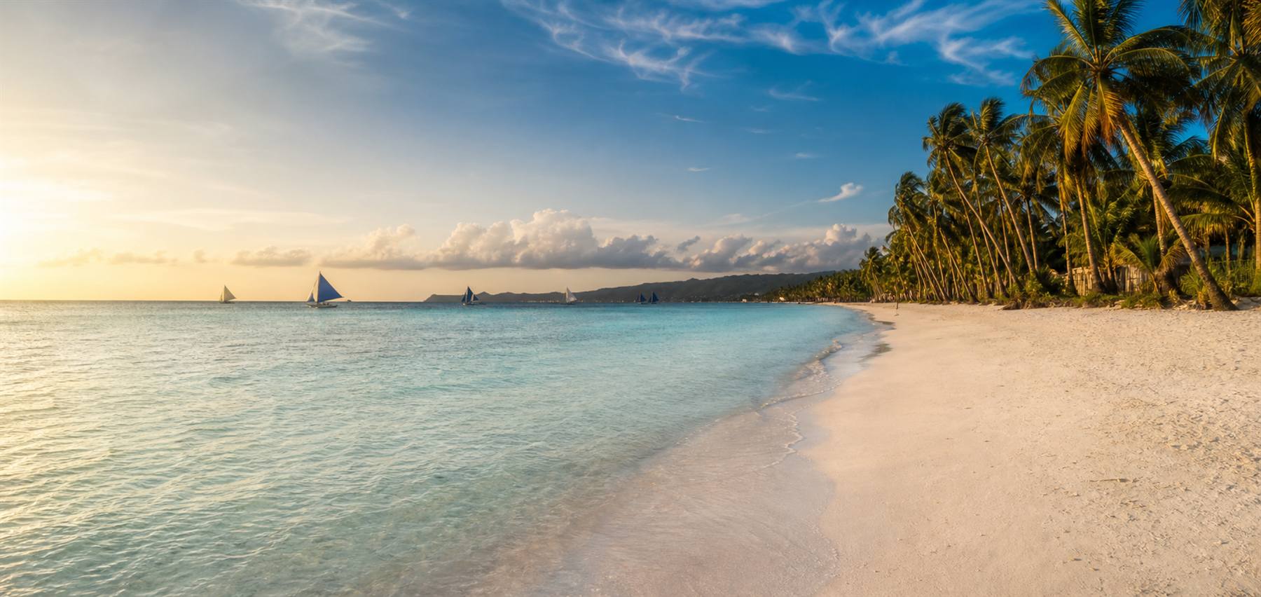 Boracay White Beach at sunrise with turquoise water and palm trees